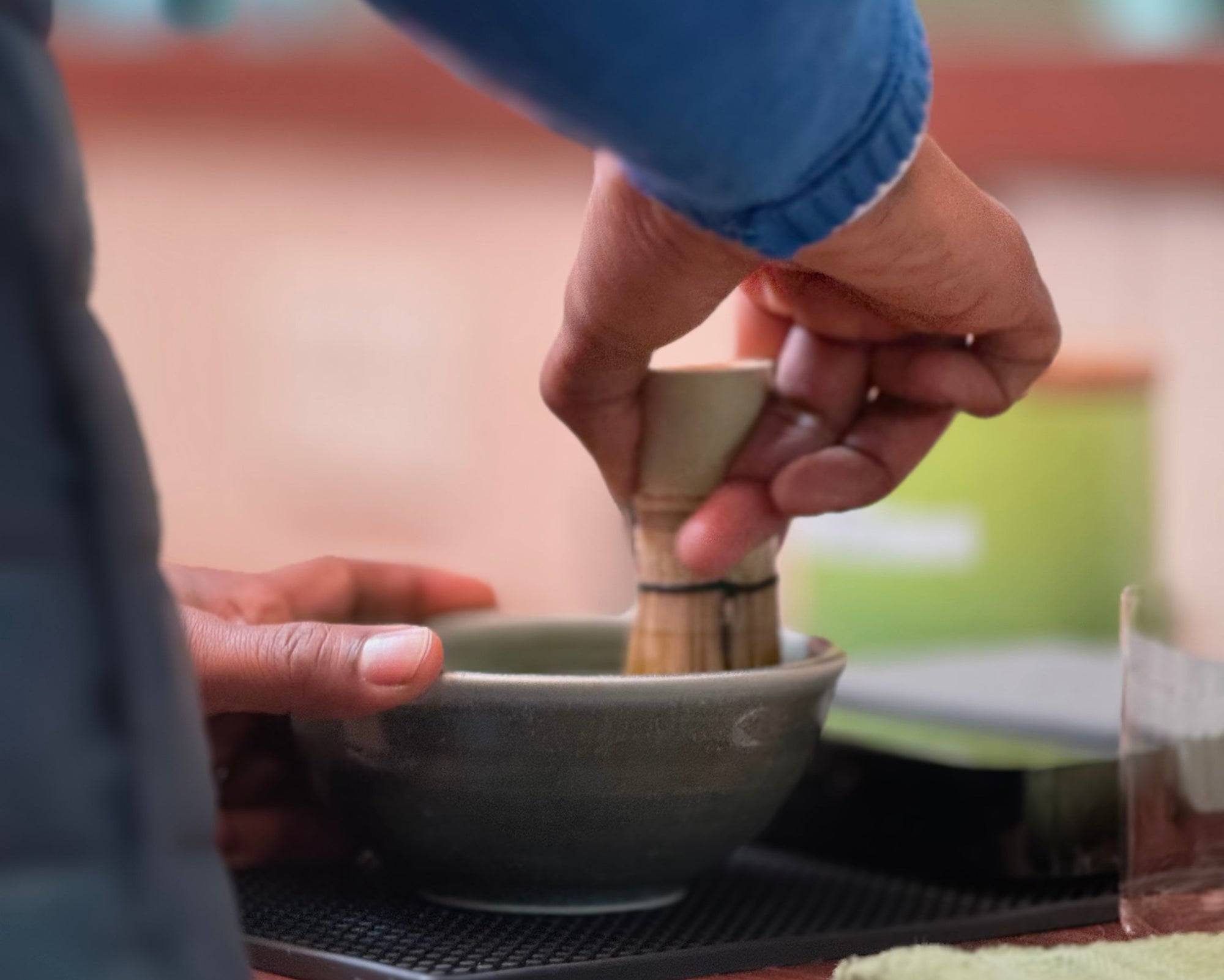 Person whisking matcha in a bowl with a chasen